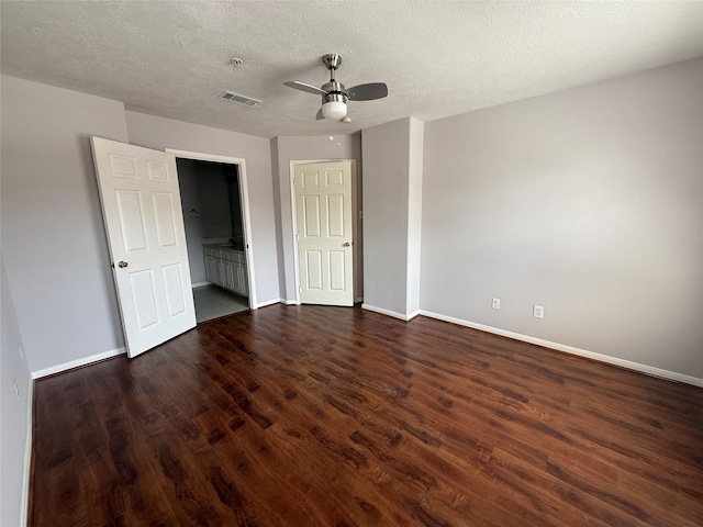 2710 Grants Lake Blvd Unit L8, Sugar Land, TX 77479 - unfurnished bedroom with baseboards, dark wood-style flooring, a textured ceiling, and ceiling fan
