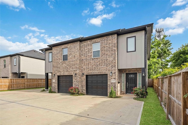 5023 Mallow St A/B, Unit A/B Houston, TX 77033 - view of front facade with concrete driveway, an attached garage, brick siding, fence, and board and batten siding