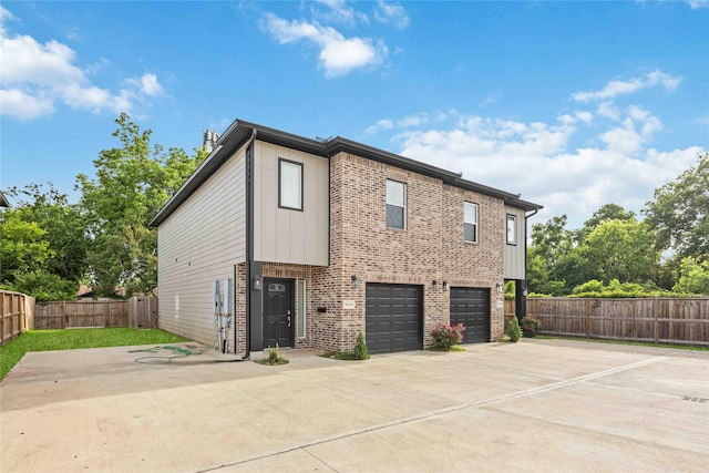 5023 Mallow St A/B, Unit A/B Houston, TX 77033 - view of side of home with an attached garage, driveway, brick siding, and fence