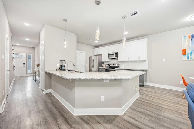 5023 Mallow St A/B, Unit A/B Houston, TX 77033 - kitchen with stainless steel appliances, a sink, light wood-style flooring, baseboards, and recessed lighting