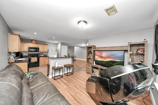living area with light wood-style floors, recessed lighting, and baseboards