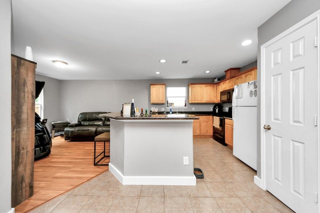 kitchen with black appliances, dark countertops, open floor plan, recessed lighting, and light brown cabinetry