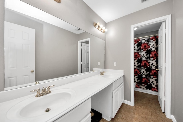 bathroom featuring double vanity and baseboards