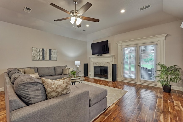 living area featuring wood finished floors, a fireplace with flush hearth, baseboards, a ceiling fan, and recessed lighting