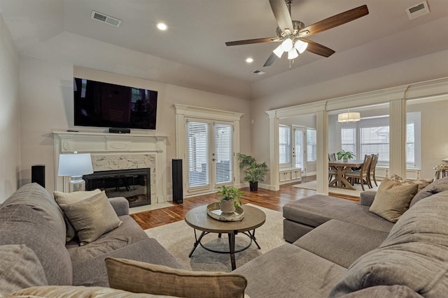 living area featuring wood finished floors, ceiling fan, recessed lighting, a high end fireplace, and baseboards