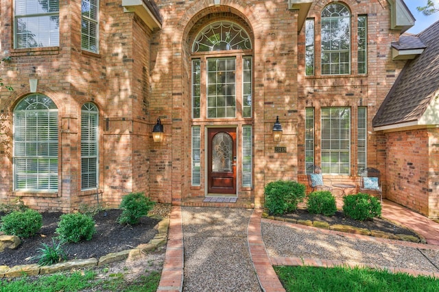 view of exterior entry with brick siding