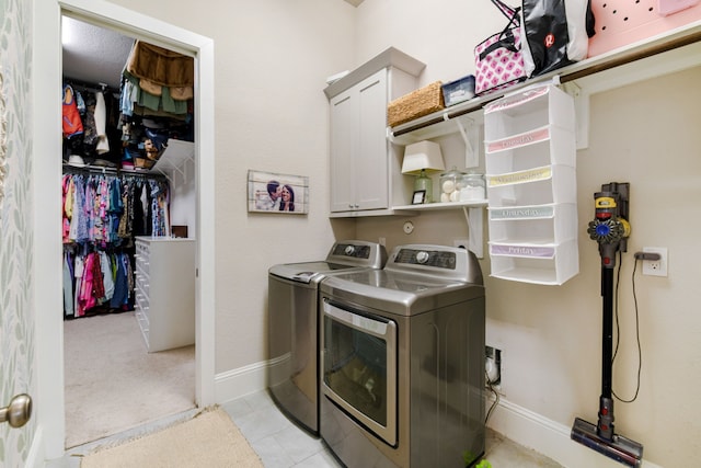 2176 Rope Maker Rd, Conroe, TX 77384 - laundry area with washer and clothes dryer, cabinet space, baseboards, and light tile patterned flooring