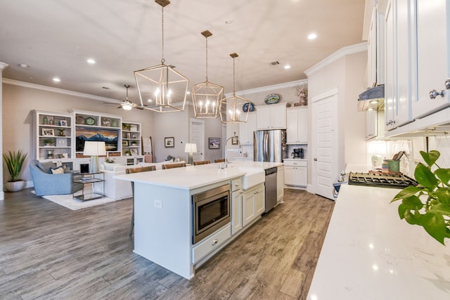 2176 Rope Maker Rd, Conroe, TX 77384 - kitchen with appliances with stainless steel finishes, a sink, open floor plan, crown molding, and a chandelier