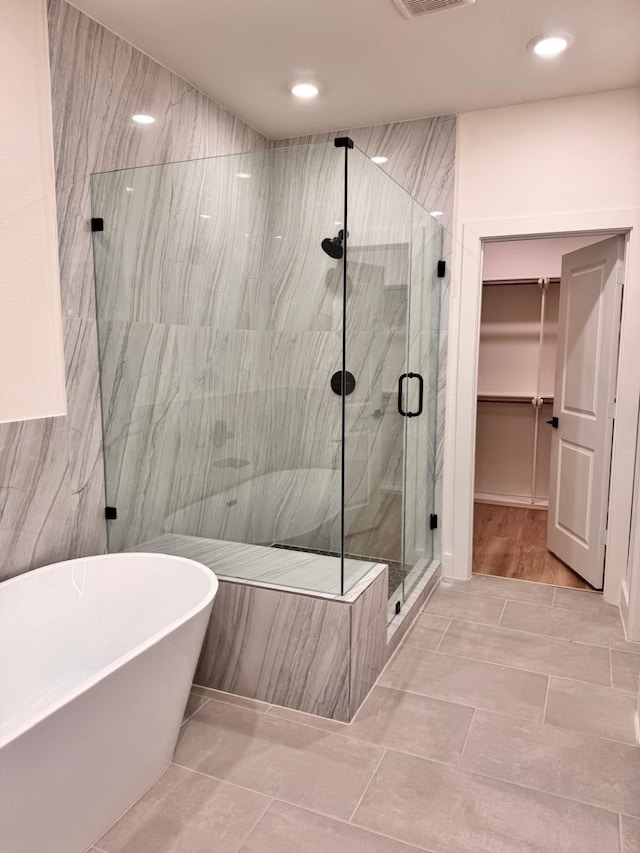 2708 Nagle St, Houston, TX 77004 - bathroom featuring a marble finish shower, a freestanding tub, a walk in closet, recessed lighting, and tile patterned flooring