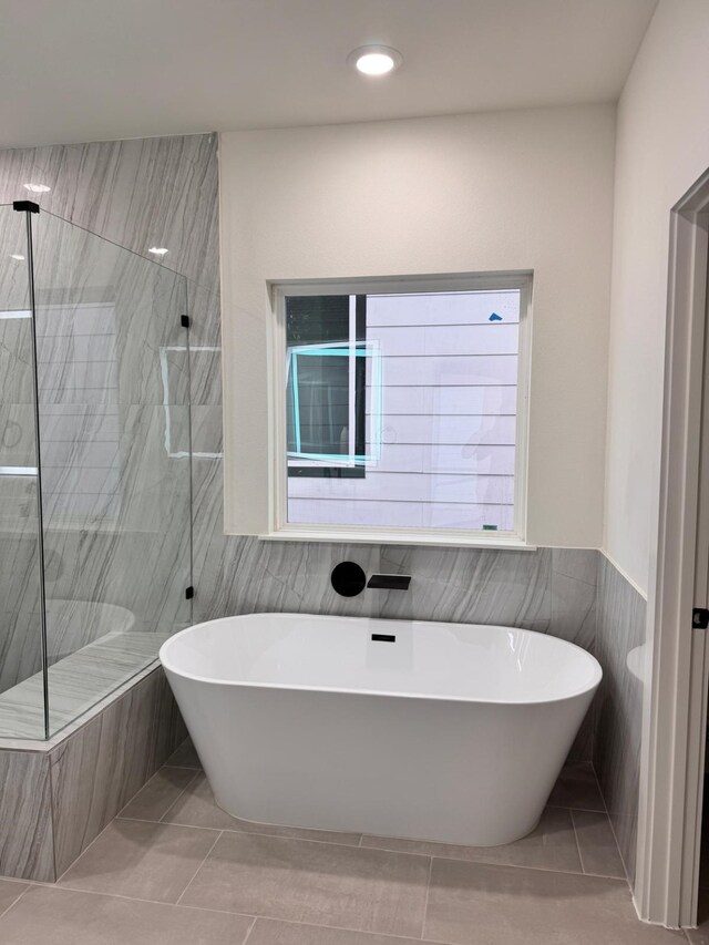 2708 Nagle St, Houston, TX 77004 - bathroom featuring tile walls, a freestanding tub, a tile shower, tile patterned floors, and recessed lighting