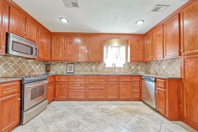711 Lodgehill Ln, Houston, TX 77090 - kitchen with appliances with stainless steel finishes, stone countertops, brown cabinetry, and recessed lighting
