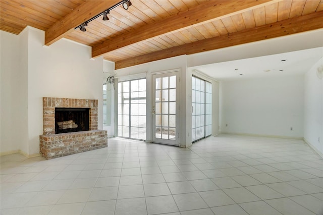 5380 Brownway St Unit D38, Houston, TX 77056 - unfurnished living room with wooden ceiling, beamed ceiling, light tile patterned flooring, a brick fireplace, and baseboards