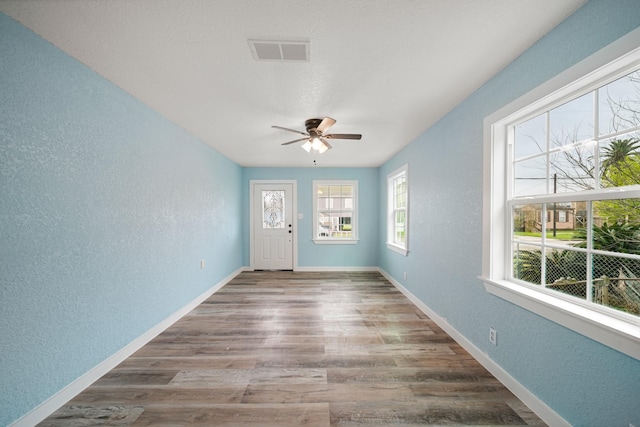 5528 Menard Ave, Galveston, TX 77551 - entrance foyer featuring a textured wall, wood finished floors, ceiling fan, and baseboards