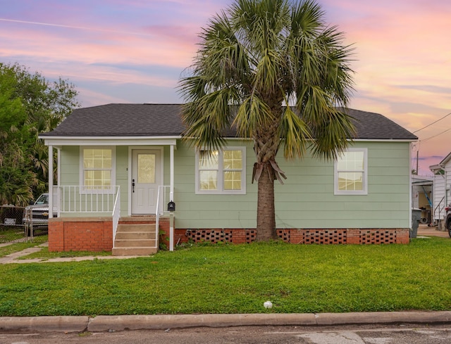 5528 Menard Ave, Galveston, TX 77551 - view of front of home with a porch, a front yard, crawl space, and roof with shingles