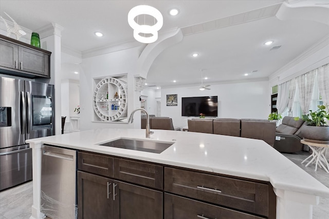 1314 Briar Cliff St, Conroe, TX 77385 - kitchen with a sink, stainless steel appliances, open floor plan, ornamental molding, and dark brown cabinets