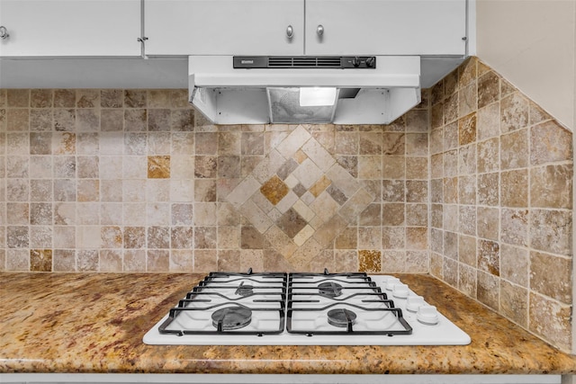 5839 Ettrick Dr, Houston, TX 77035 - kitchen with under cabinet range hood, white gas stovetop, and backsplash