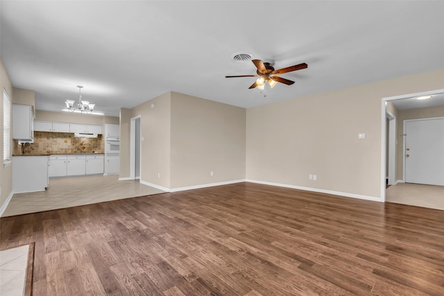 5839 Ettrick Dr, Houston, TX 77035 - unfurnished living room with a chandelier, ceiling fan, wood finished floors, and baseboards