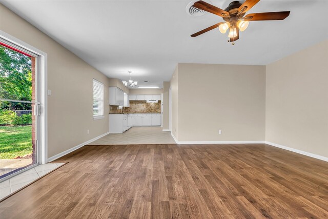 5839 Ettrick Dr, Houston, TX 77035 - unfurnished living room with a chandelier, light wood finished floors, a ceiling fan, and baseboards