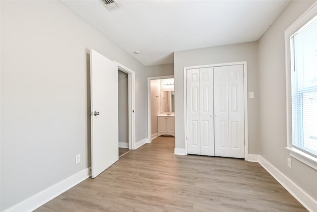 801 S Travis Ave, Cleveland, TX 77327 - unfurnished bedroom with light wood-style flooring, baseboards, and a closet