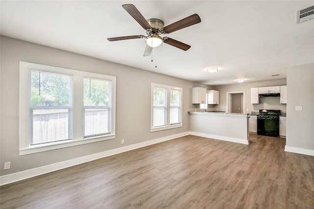 801 S Travis Ave, Cleveland, TX 77327 - unfurnished living room with wood finished floors, baseboards, and ceiling fan