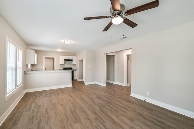 801 S Travis Ave, Cleveland, TX 77327 - unfurnished living room with dark wood-style flooring, baseboards, and ceiling fan