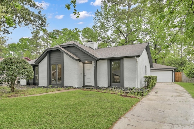 mid-century modern home featuring a garage, brick siding, a shingled roof, and a chimney