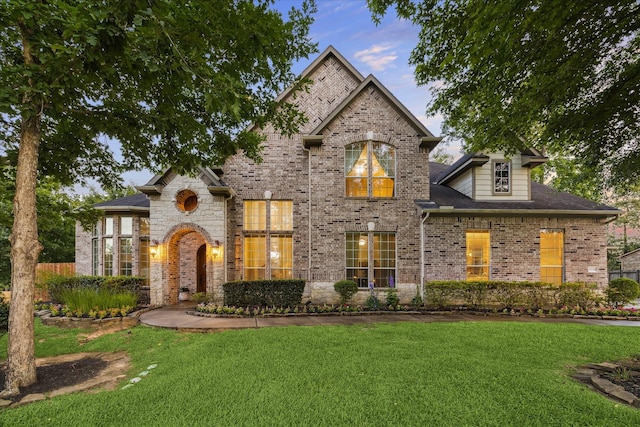 10114 Logan Grove Ct, Conroe, TX 77302 - french country inspired facade featuring a front yard and brick siding