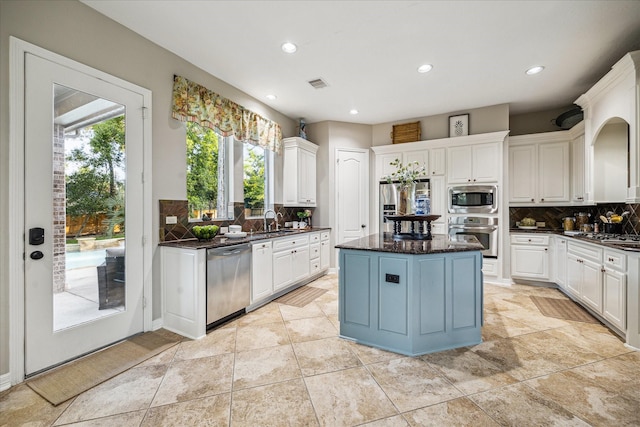 10114 Logan Grove Ct, Conroe, TX 77302 - kitchen featuring stainless steel appliances, a sink, decorative backsplash, a center island, and recessed lighting