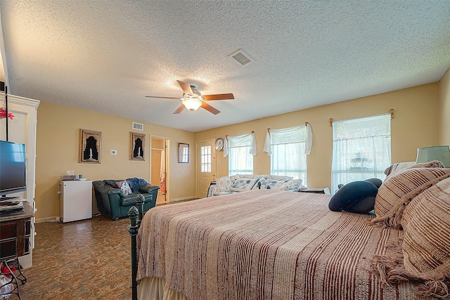 220 Hillcrest Dr, Coldspring, TX 77331 - bedroom featuring baseboards, a textured ceiling, and ceiling fan