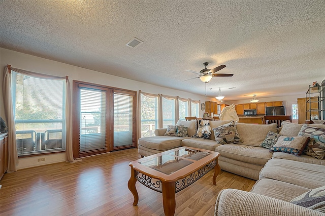 220 Hillcrest Dr, Coldspring, TX 77331 - living area featuring light wood-type flooring, a ceiling fan, and a textured ceiling