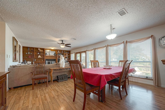 220 Hillcrest Dr, Coldspring, TX 77331 - dining space with light wood finished floors, a ceiling fan, plenty of natural light, and a textured ceiling