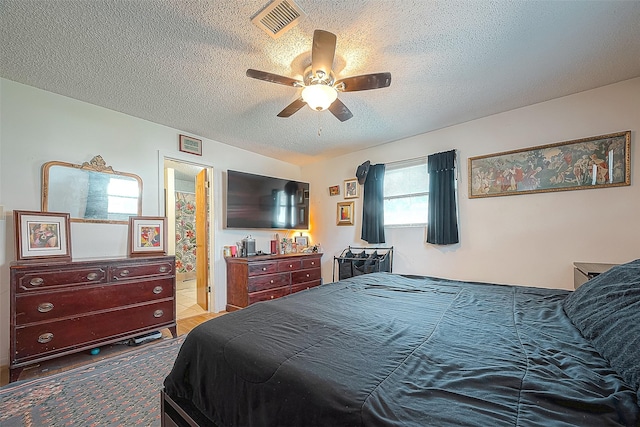 220 Hillcrest Dr, Coldspring, TX 77331 - bedroom with a textured ceiling, a ceiling fan, and ensuite bathroom