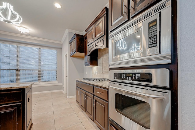 18306 S Austin Shore Dr, Cypress, TX 77433 - kitchen featuring appliances with stainless steel finishes, light tile patterned floors, dark brown cabinets, crown molding, and light stone counters