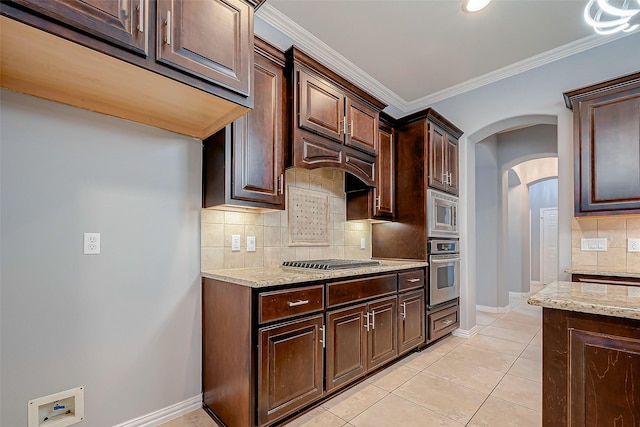 18306 S Austin Shore Dr, Cypress, TX 77433 - kitchen featuring stainless steel appliances, arched walkways, light stone counters, tasteful backsplash, and dark brown cabinets