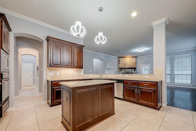 18306 S Austin Shore Dr, Cypress, TX 77433 - kitchen featuring stainless steel appliances, a sink, ornamental molding, arched walkways, and tasteful backsplash
