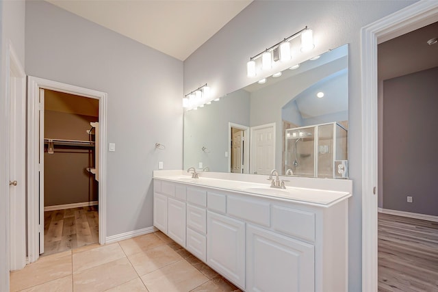18306 S Austin Shore Dr, Cypress, TX 77433 - bathroom with a stall shower, baseboards, a spacious closet, double vanity, and tile patterned flooring