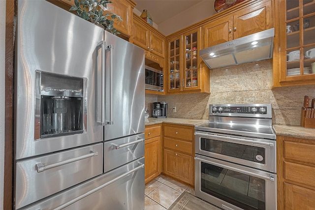 1241 Terrazas Ln, Sealy, TX 77474 - kitchen with appliances with stainless steel finishes, under cabinet range hood, backsplash, and brown cabinets