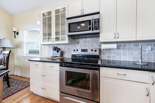 171 County Road 299, Sargent, TX 77414 - kitchen featuring stainless steel appliances, baseboards, tasteful backsplash, and light wood-type flooring