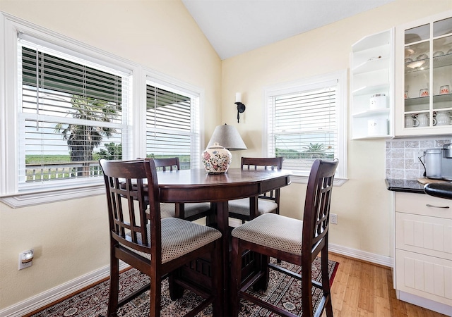 171 County Road 299, Sargent, TX 77414 - dining space featuring lofted ceiling, healthy amount of natural light, light wood finished floors, and baseboards
