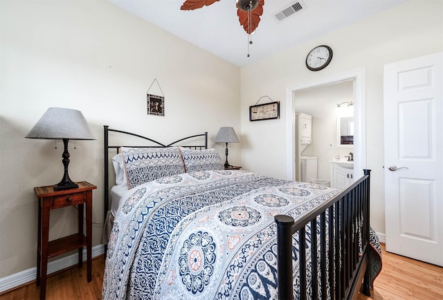 171 County Road 299, Sargent, TX 77414 - bedroom with light wood-type flooring, ensuite bath, baseboards, and a ceiling fan