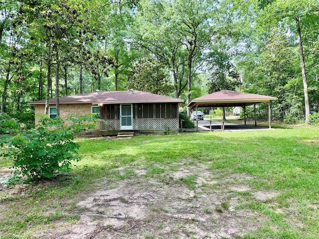 202 Spring Creek Loop, Livingston, TX 77351 - view of grassy yard with a detached carport and a sunroom