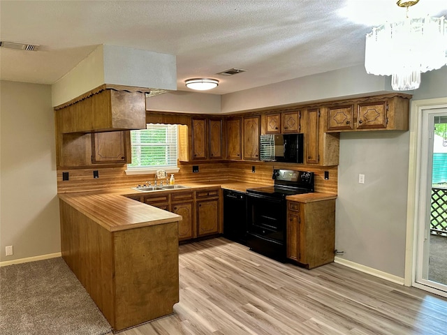 202 Spring Creek Loop, Livingston, TX 77351 - kitchen with black appliances, a sink, brown cabinets, a peninsula, and light countertops