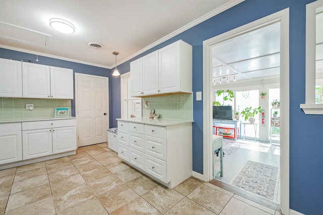 1902 Bayou Shore Dr, Galveston, TX 77551 - kitchen featuring backsplash, white cabinetry, ornamental molding, light countertops, and decorative light fixtures