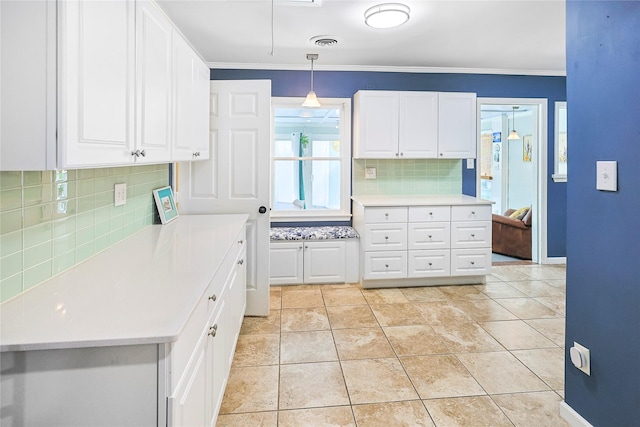 1902 Bayou Shore Dr, Galveston, TX 77551 - kitchen featuring decorative backsplash, white cabinetry, ornamental molding, light countertops, and hanging light fixtures