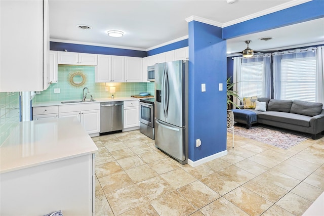 1902 Bayou Shore Dr, Galveston, TX 77551 - kitchen featuring stainless steel appliances, ornamental molding, light countertops, white cabinets, and decorative backsplash
