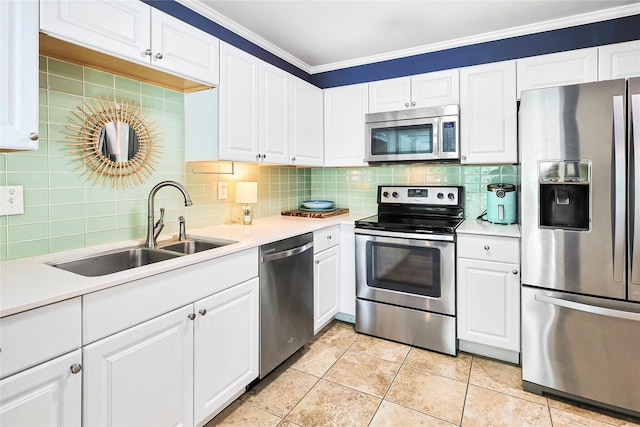 1902 Bayou Shore Dr, Galveston, TX 77551 - kitchen featuring appliances with stainless steel finishes, light countertops, decorative backsplash, white cabinetry, and crown molding