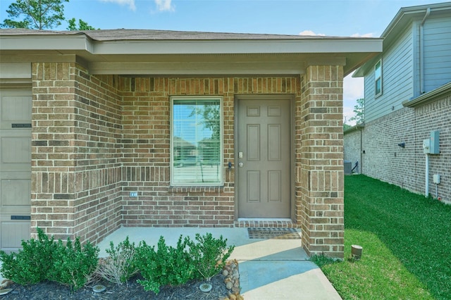 16953 Rich Pines Dr, Conroe, TX 77302 - view of exterior entry with brick siding and a lawn