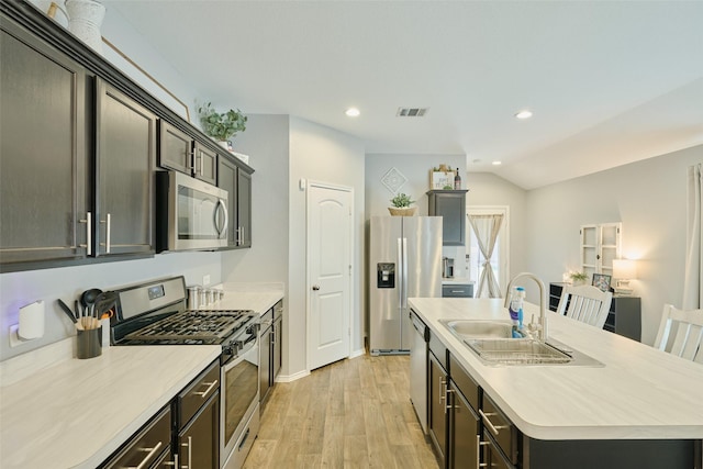 16953 Rich Pines Dr, Conroe, TX 77302 - kitchen with appliances with stainless steel finishes, a kitchen island with sink, light wood-style floors, light countertops, and a sink