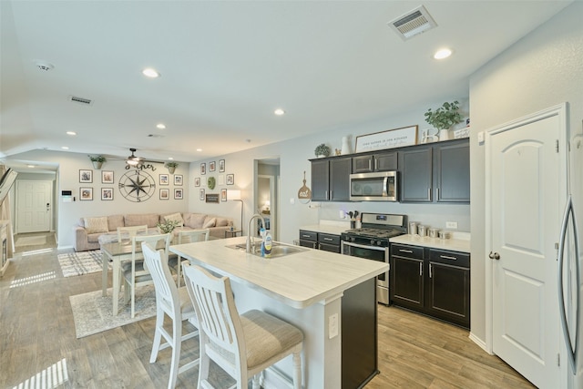 16953 Rich Pines Dr, Conroe, TX 77302 - kitchen with stainless steel appliances, a sink, open floor plan, an island with sink, and ceiling fan