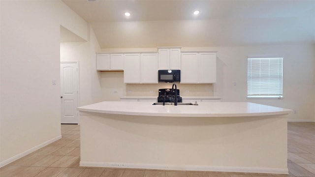 32307 Elmwood Mnr, Waller, TX 77484 - kitchen featuring black microwave, a sink, tasteful backsplash, white cabinets, and a kitchen island with sink